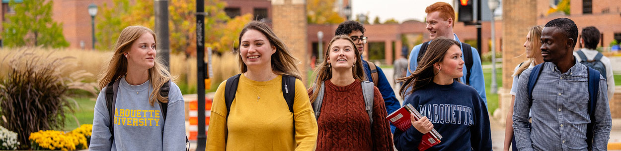 Many students walking across Wisconsin Avenue on Marquette University Campus.