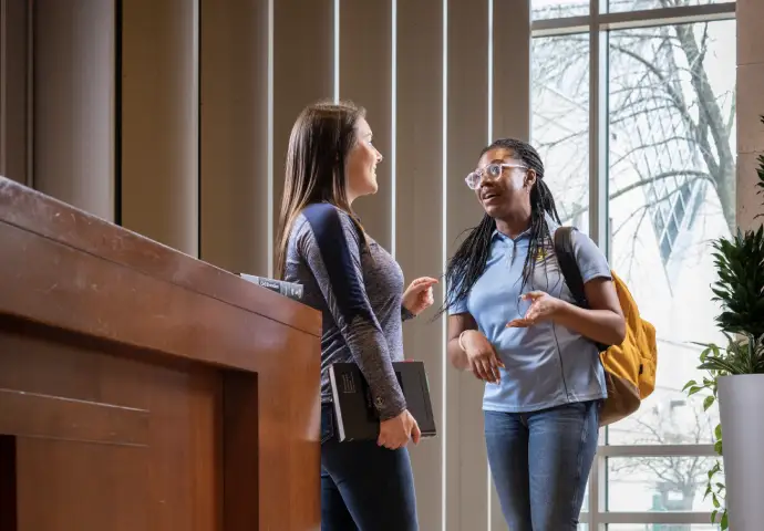 students enjoy a conversation near a desk