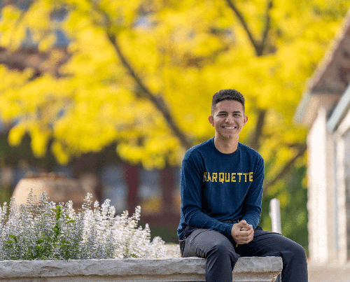 Man sitting by some flowers