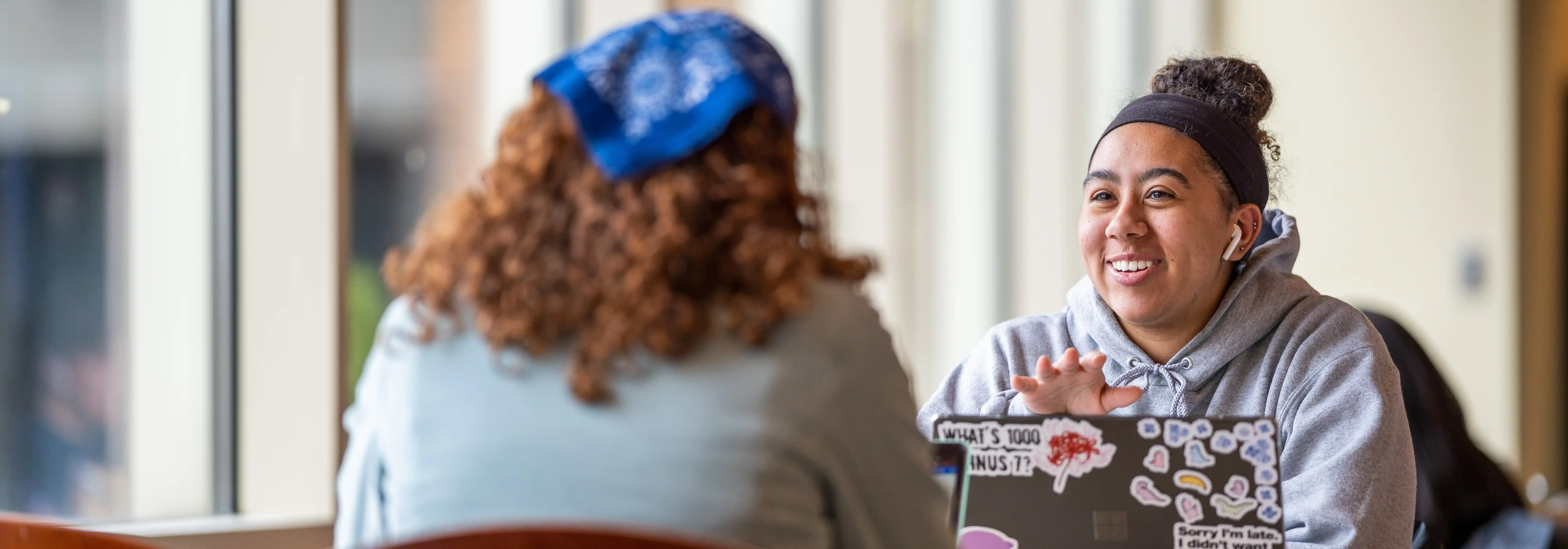 student sitting at a table and talking