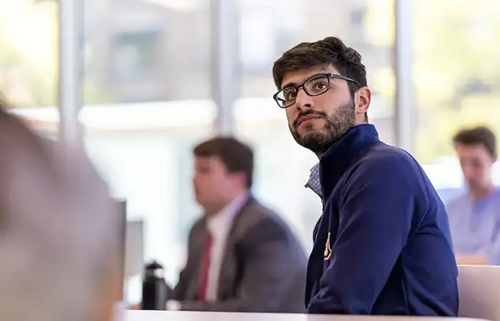 student dentist poses in front of dentist chair