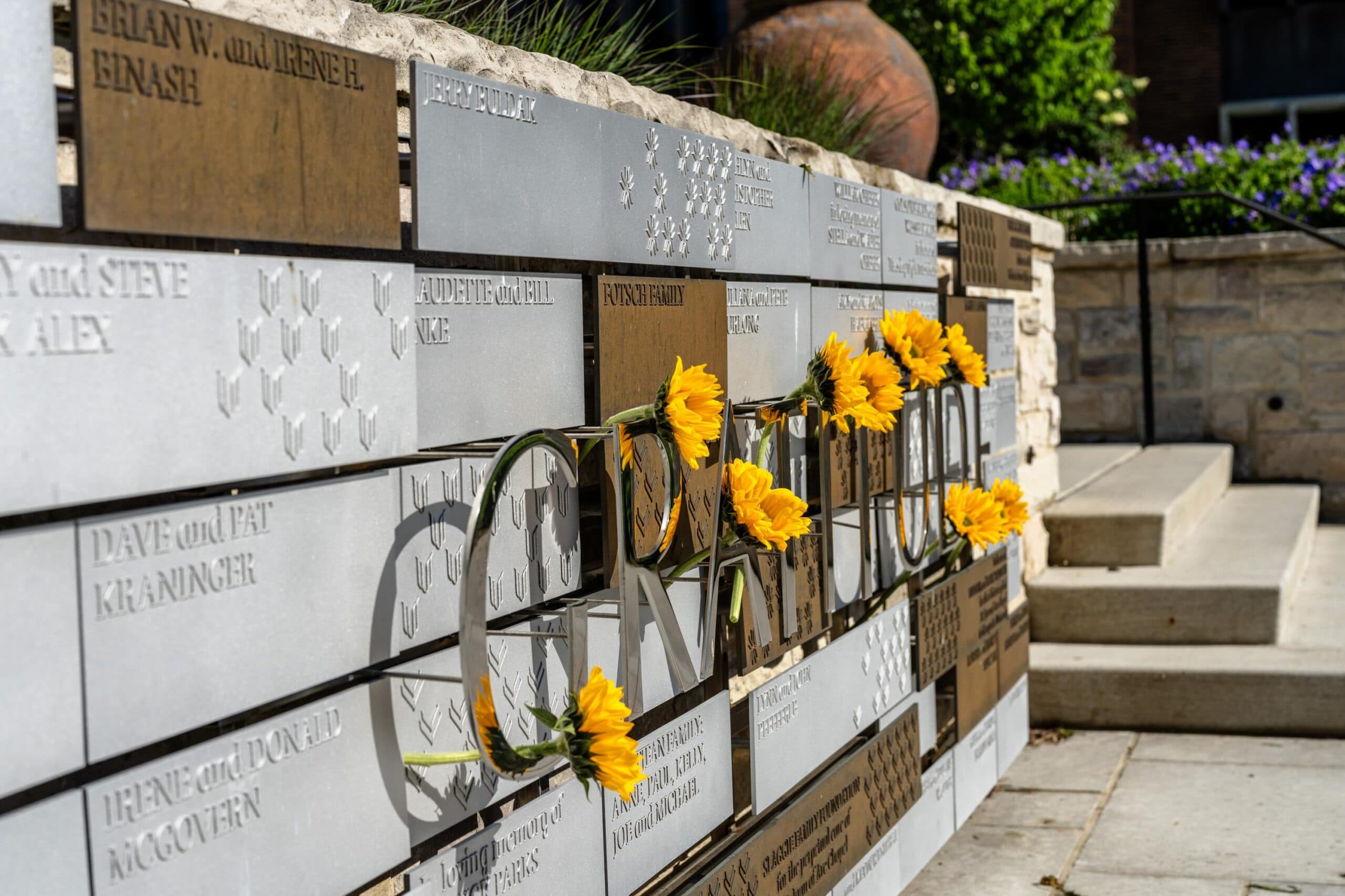 A close up of sunflowers on a donor wall near St. Joan of Arc chapel steps.