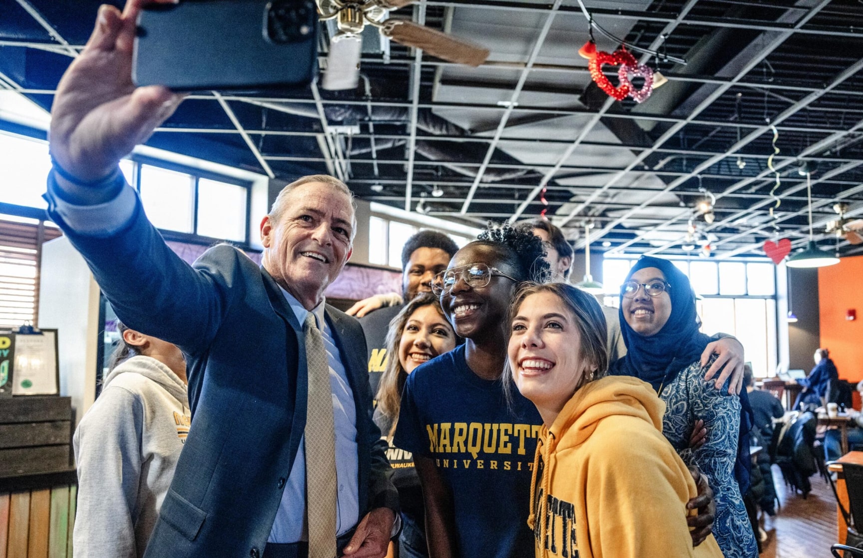 President Lovell taking a selfie with a group of students in The Brew.