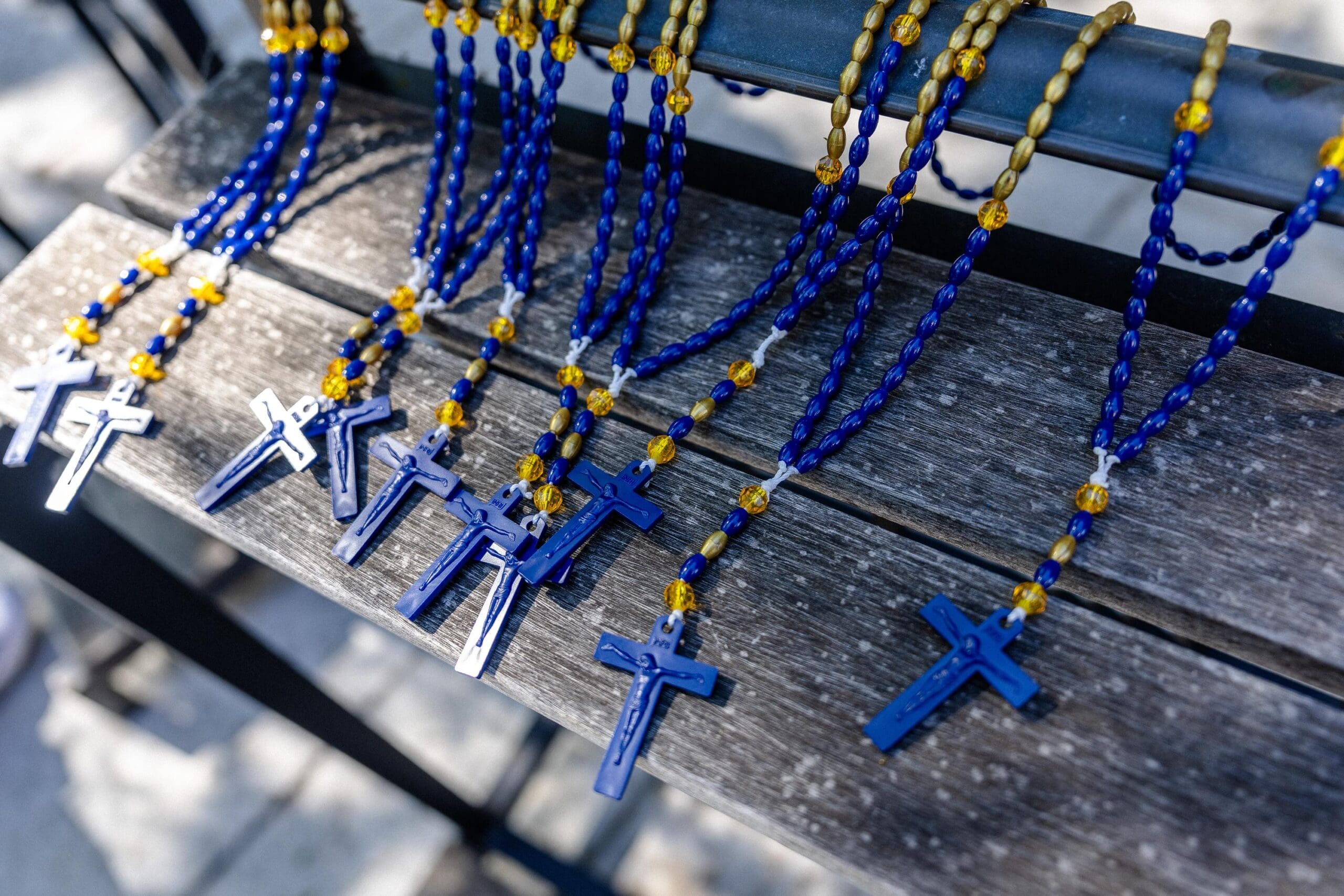 A close up of blue and gold rosary beads.